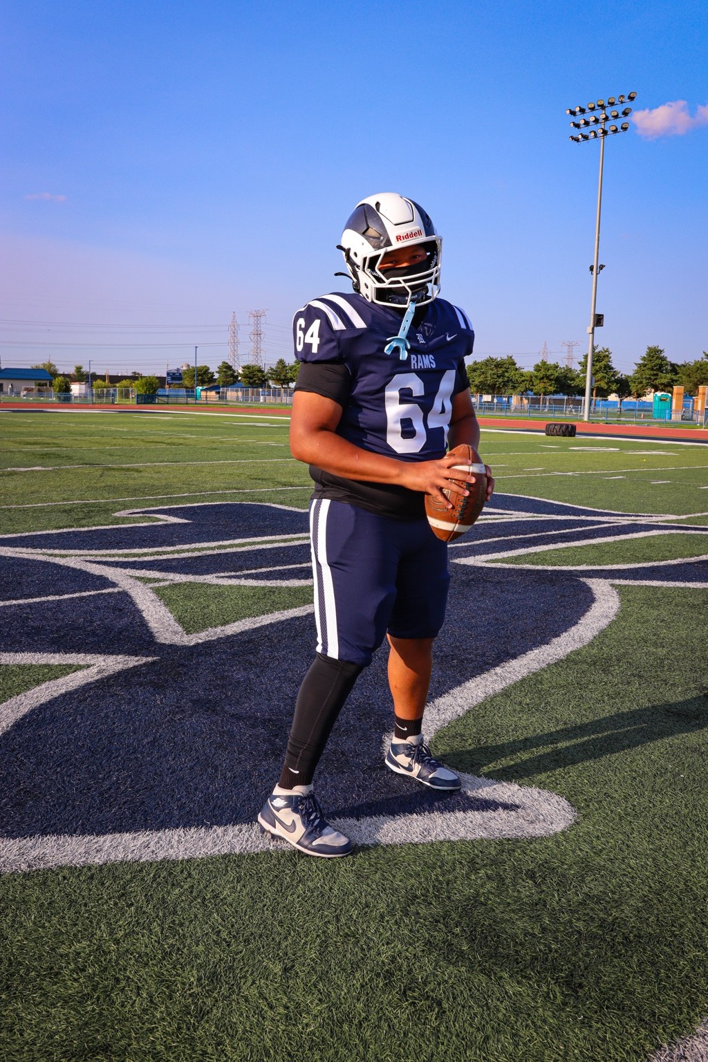 Football player holding a football on the field