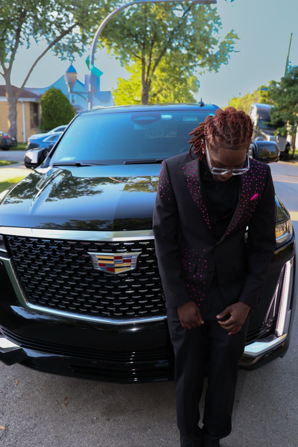 Formal portrait in front of a Cadillac