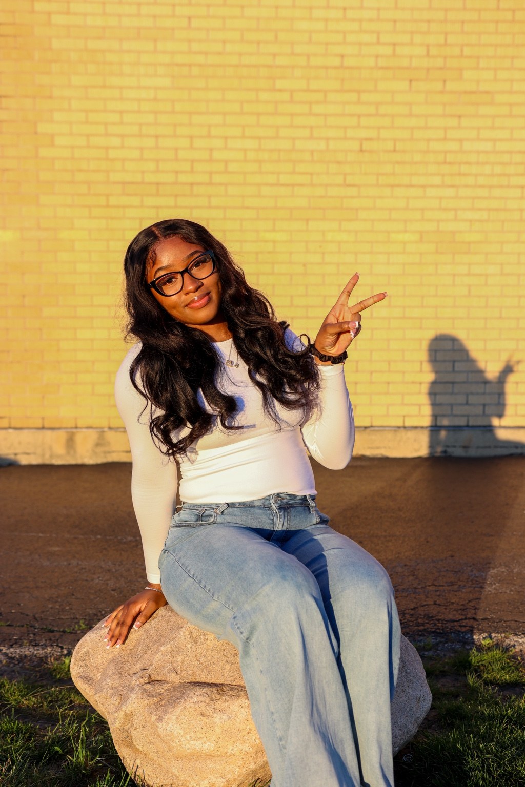 Outdoor portrait seated against a brick wall